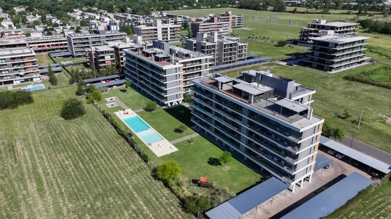 Vista aérea de Tierra Nueva, Fisherton: condos terminados, pileta y espacios verdes